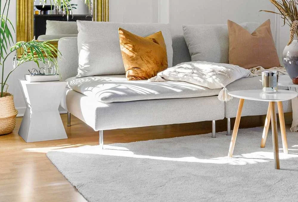 Salon lumineux avec canapé gris, mobilier en bois et décoration intérieure contemporaine